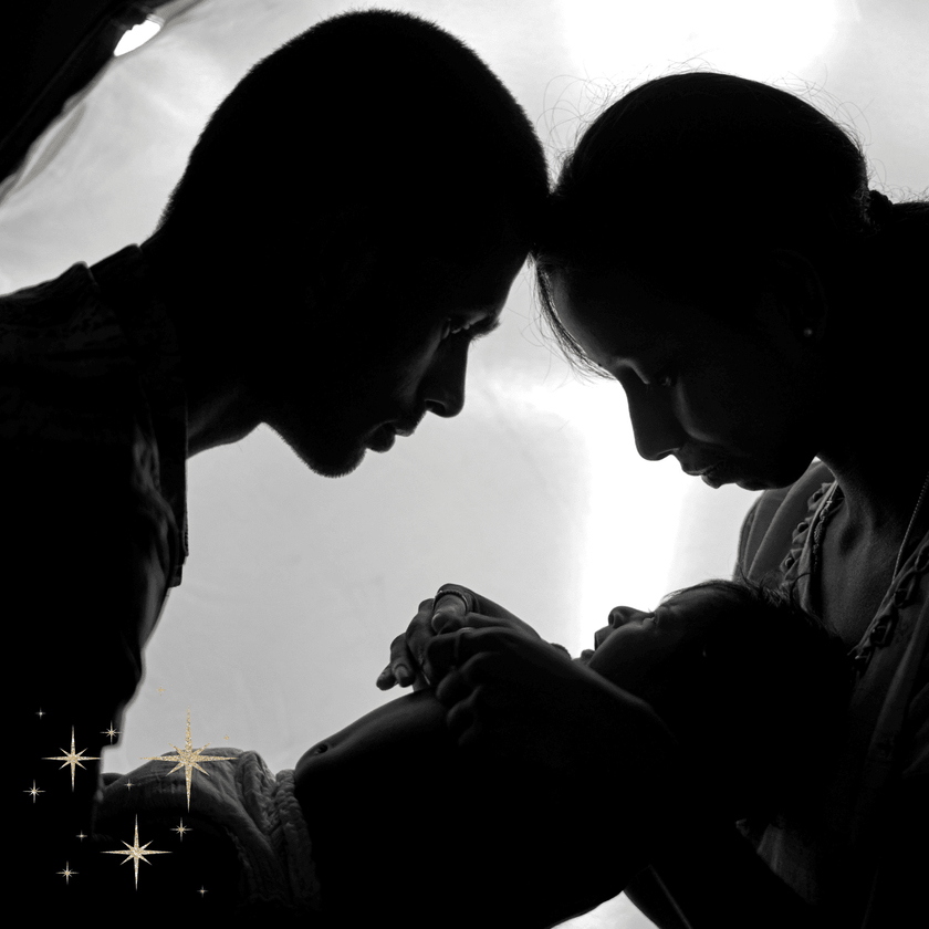 Black and white silhouette of two people holding hands against a light background