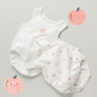 White baby romper with pink peach pattern on a background