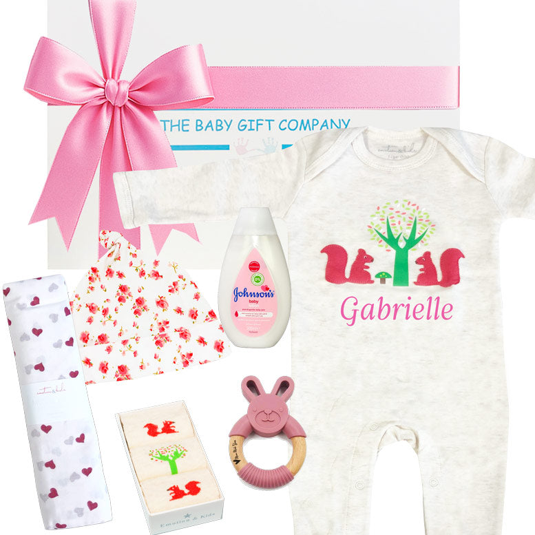Baby gift set with personalized onesie, Johnson's baby bottle, and other items on a white background.