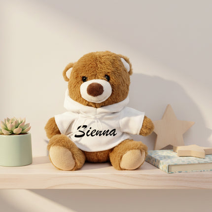 Personalised brown hoodie teddy bear with custom baby name sitting on a shelf