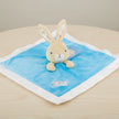 Plush toy rabbit on a blue blanket with a white border on table