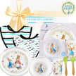 Children's dinner set with 'Peter Rabbit' theme, including plates, cup, and bib, branded by The Baby Gift Company.