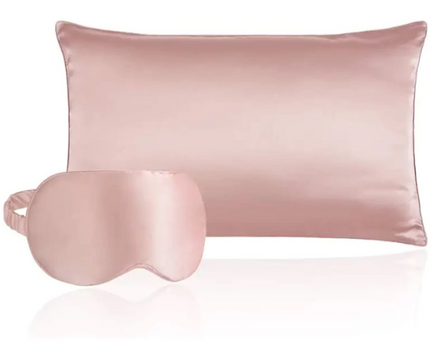 Silky pink pillow and matching eye mask on a white background