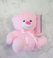 Pink teddy bear with a white bow on a light gray background