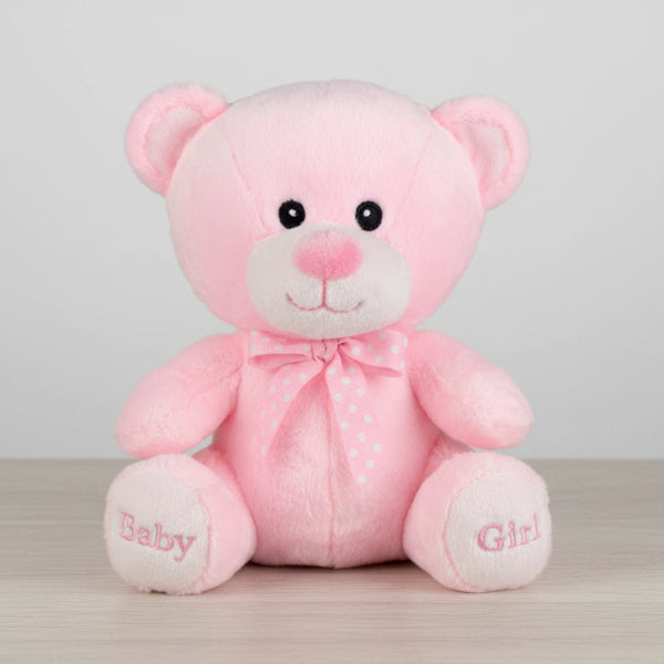 Pink teddy bear with a bow tie on a table background