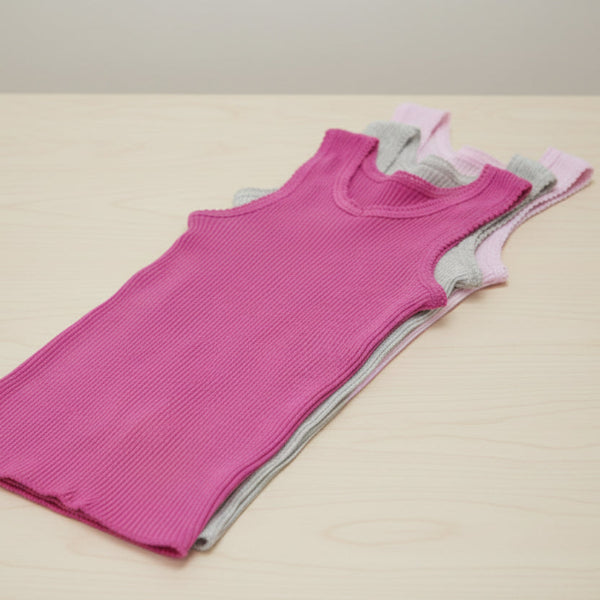bonds Two ribbed tank tops, one pink and one gray, on a table background