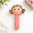 Pink doll with brown hair, squeaker plush toy on a white table background