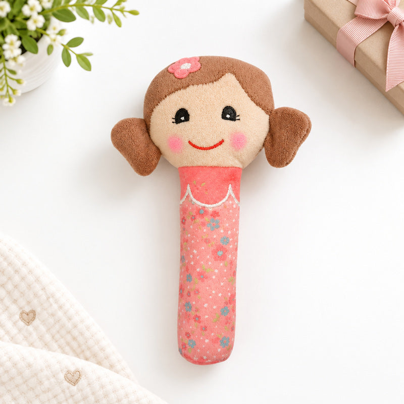 Pink doll with brown hair, squeaker plush toy on a white table background