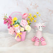 Pink Easter basket with flowers and a plush bunny on a light background