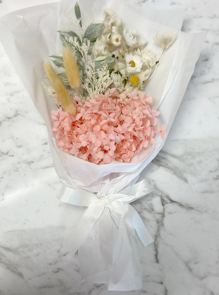 Bouquet of pink flowers and greenery on a marble surface