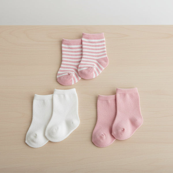 Set of four pairs of pink and white striped socks on a table