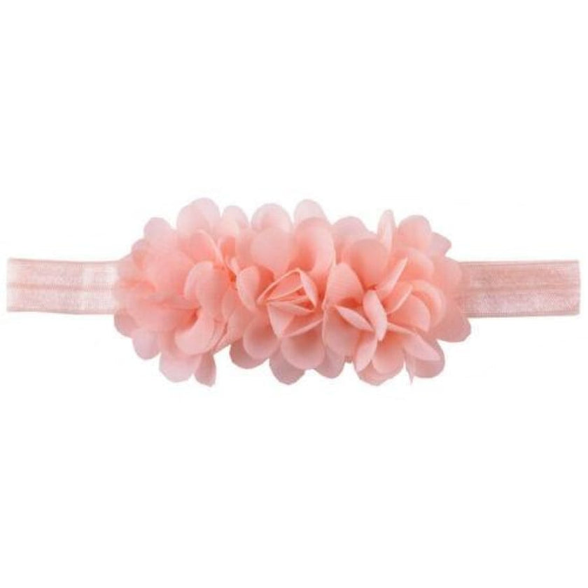 Pink headband with floral attachments on a white background