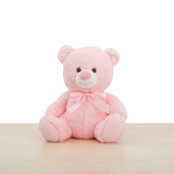 Pink teddy bear with a bow on a table background