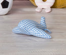 Blue and white checkered toy airplane on a wooden floor with other toys in the background.
