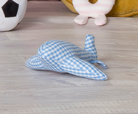 Blue and white checkered toy airplane on a wooden floor with other toys in the background.