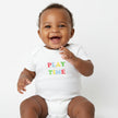 baby wearing white romper with play time wording