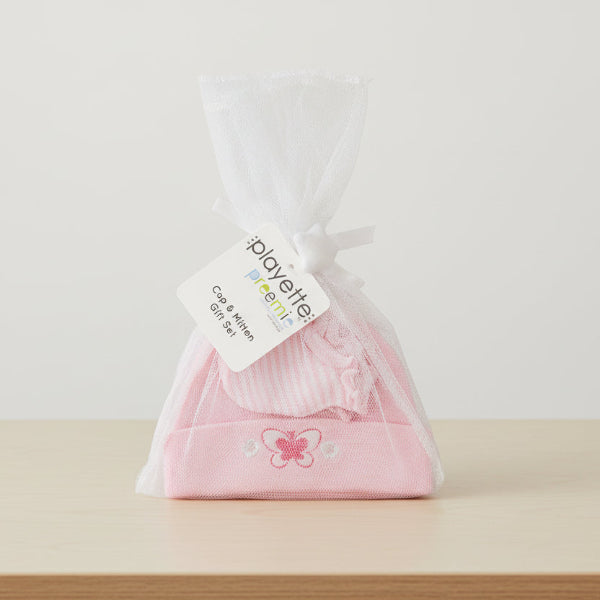 Pink baby hat with butterfly design in a clear bag, featuring a Playette label.