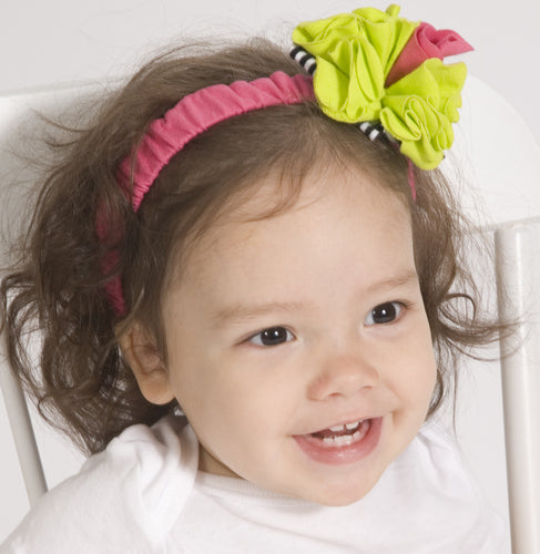 Child wearing a colorful headband with a large bow on a white background