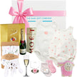 Collection of luxury  baby gift items including a onesie, bottle, and toys with a branded box from The baby gift company