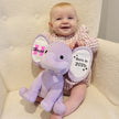 Baby sitting in chair with Purple Plush Elephant
