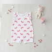 Baby romper with red and blue half-circle pattern on a table background