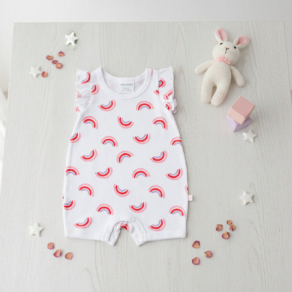 Baby romper with red and blue half-circle pattern on a table background