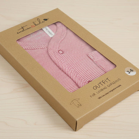 red baby soft cotton bodysuit in a cardboard box with 'emotion & kids' branding