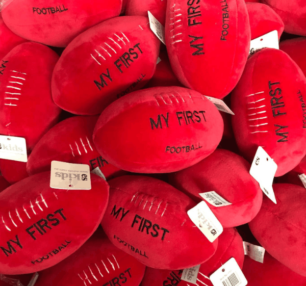 Red 'My First Football' toys with visible branding on a pile.
