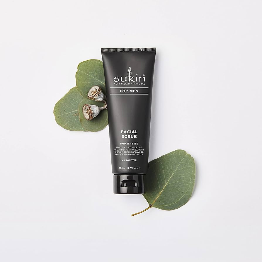 Sukin for Men Facial Scrub tube with eucalyptus leaves on a white background