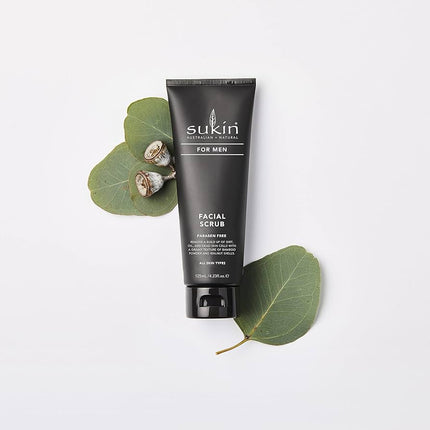 Sukin for Men Facial Scrub tube with eucalyptus leaves on a white background