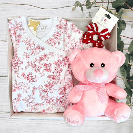 Baby outfit with floral pattern and pink teddy bear in a box from The Baby Gift Company