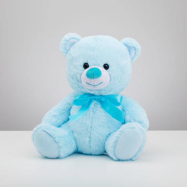 Blue teddy bear with a bow on a table background