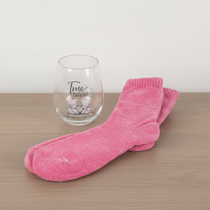 Pink socks and a glass with 'True Friend' text on a table background