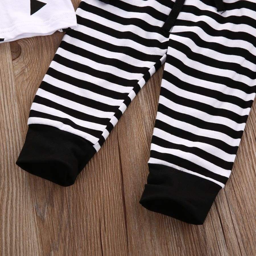 Black and white striped baby leggings on a wooden surface