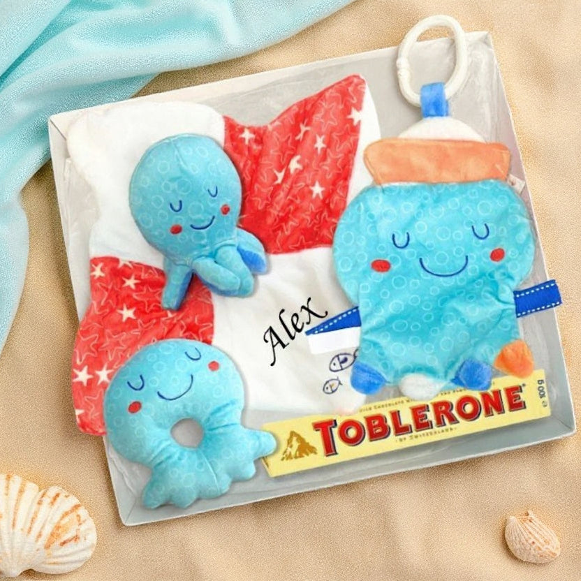 Gift box with blue octopus baby toys on a beach background