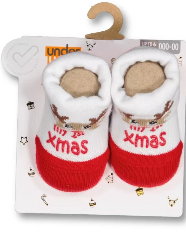 Pair of baby booties with 'Merry Xmas' text on a branded package.