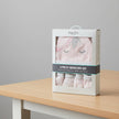 Boxed 3-piece newborn set with baby booties, beanie, and mittens on a table