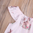 Baby romper with bunny print on a wooden surface