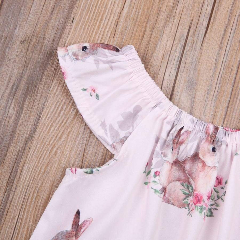 Baby romper with bunny print on a wooden surface