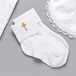 White sock with a gold cross on a gray surface