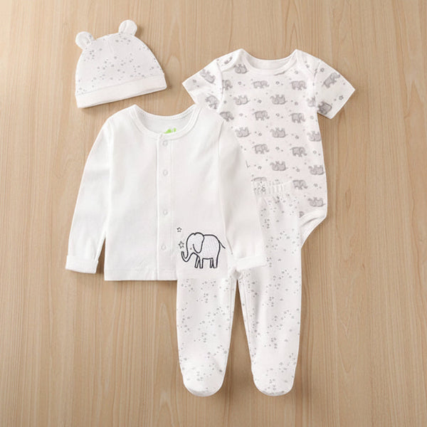 Baby clothing set with onesie, romper, and hat on a wooden background