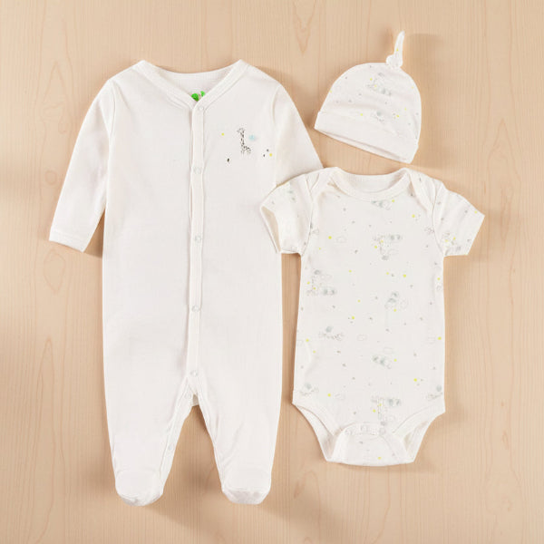 Baby clothing set with onesie, romper, and hat on a table