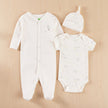 Baby clothing set with onesie, romper, and hat on a table