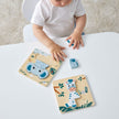 Two Wooden animal Puzzles with a child on a table