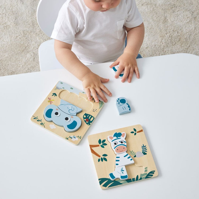 Two Wooden animal Puzzles with a child on a table