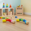 Colorful caterpillar-shaped toys on wooden floor