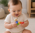 Baby holding Colorful caterpillar-shaped toy, sitting on a floor