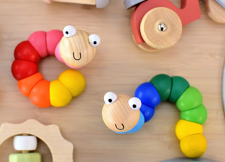 Colorful wooden caterpillar toys on a wooden surface