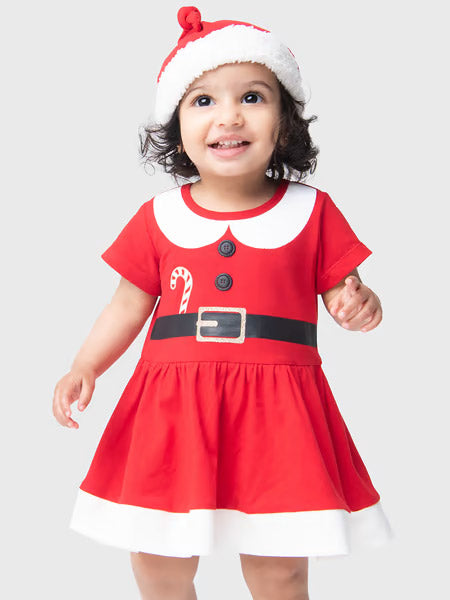 Child wearing a red Santa dress with a white hat on a light gray background
